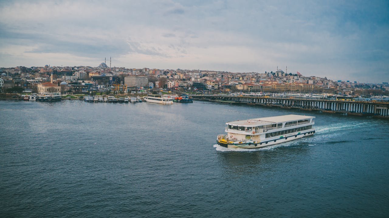 A boat traveling on the water near a city